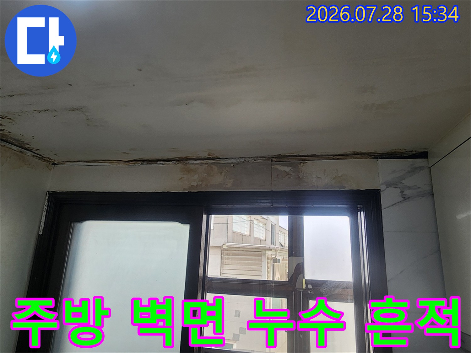 창문 위쪽 천장 경계선에 발생한 누수 얼룩과 변색