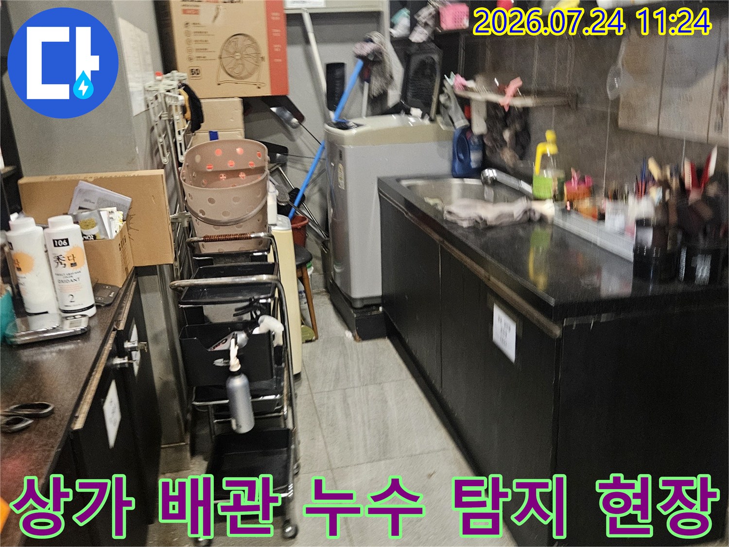 공구와 장비가 배치된 상가 바닥의 누수 탐지 작업 현장
