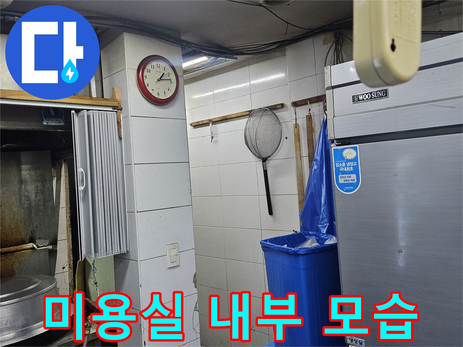 냉장고와 파란색 통이 있는 미용실 샴푸대 주변입니다.