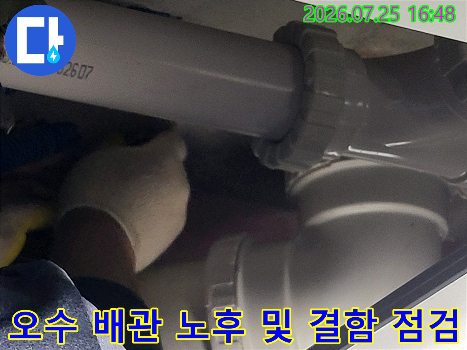 작업자가 장갑을 끼고 화장실 오수 배관의 굴곡부를 세밀하게 살피는 모습