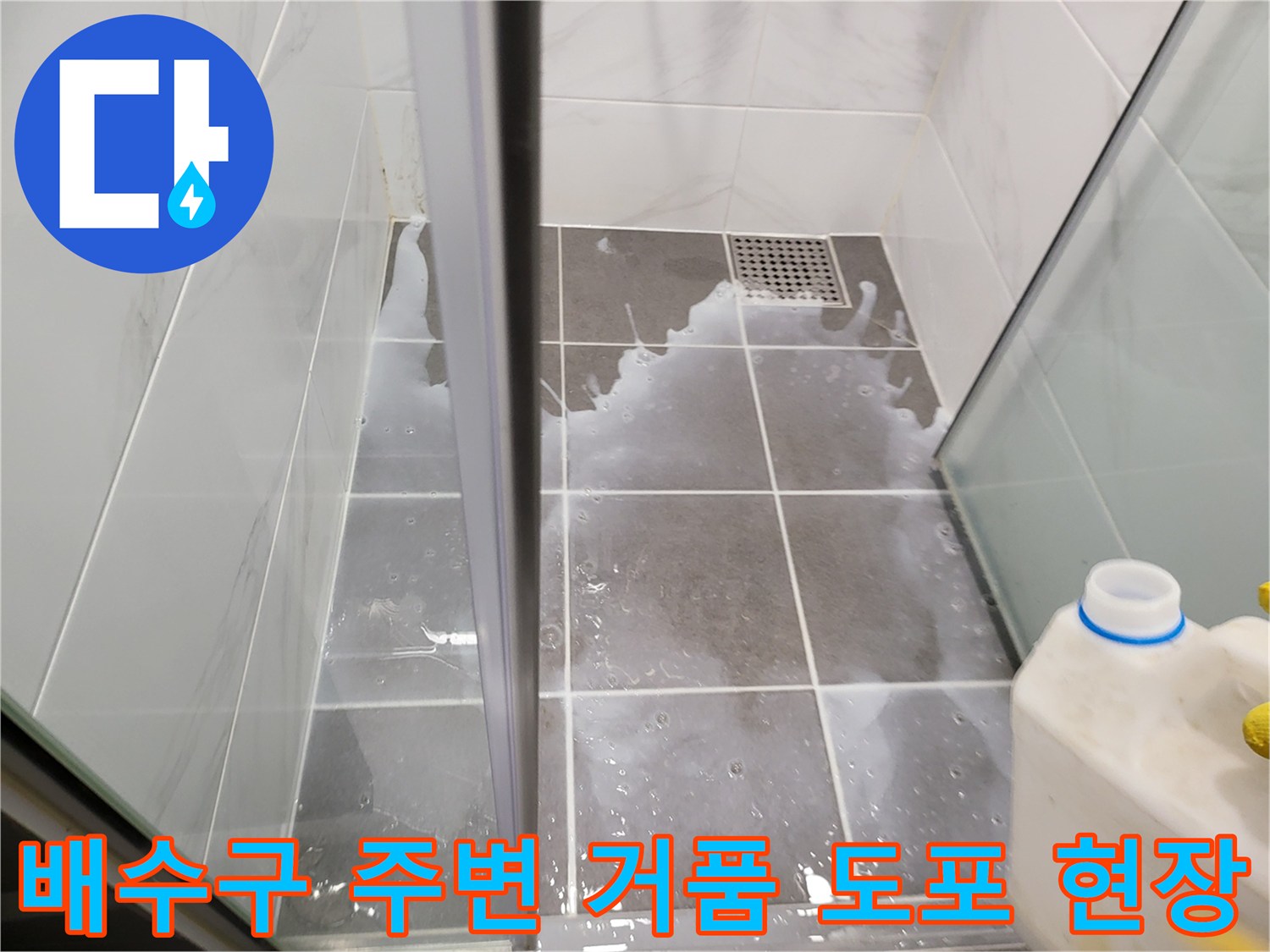 화장실 배수구 주위에 하얀 거품이 덮여 있는 상태의 사진