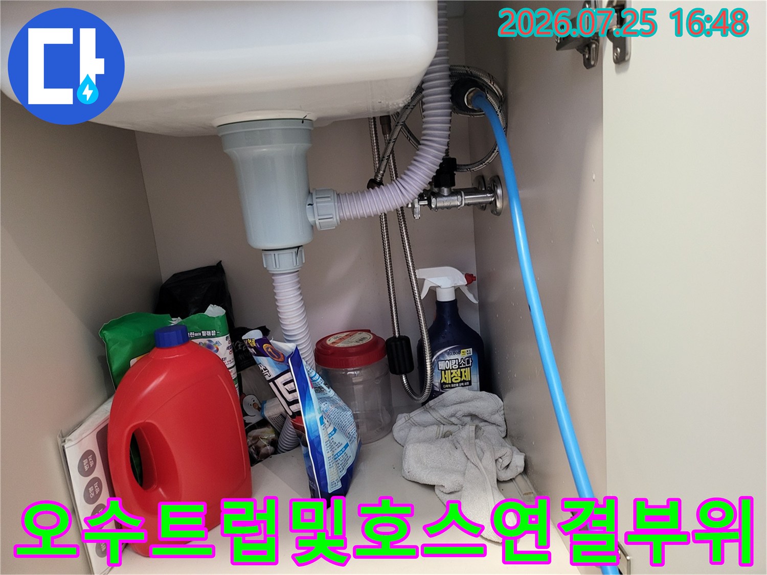 회색 배출구와 파란 호스가 연결된 화장실 내부 공간