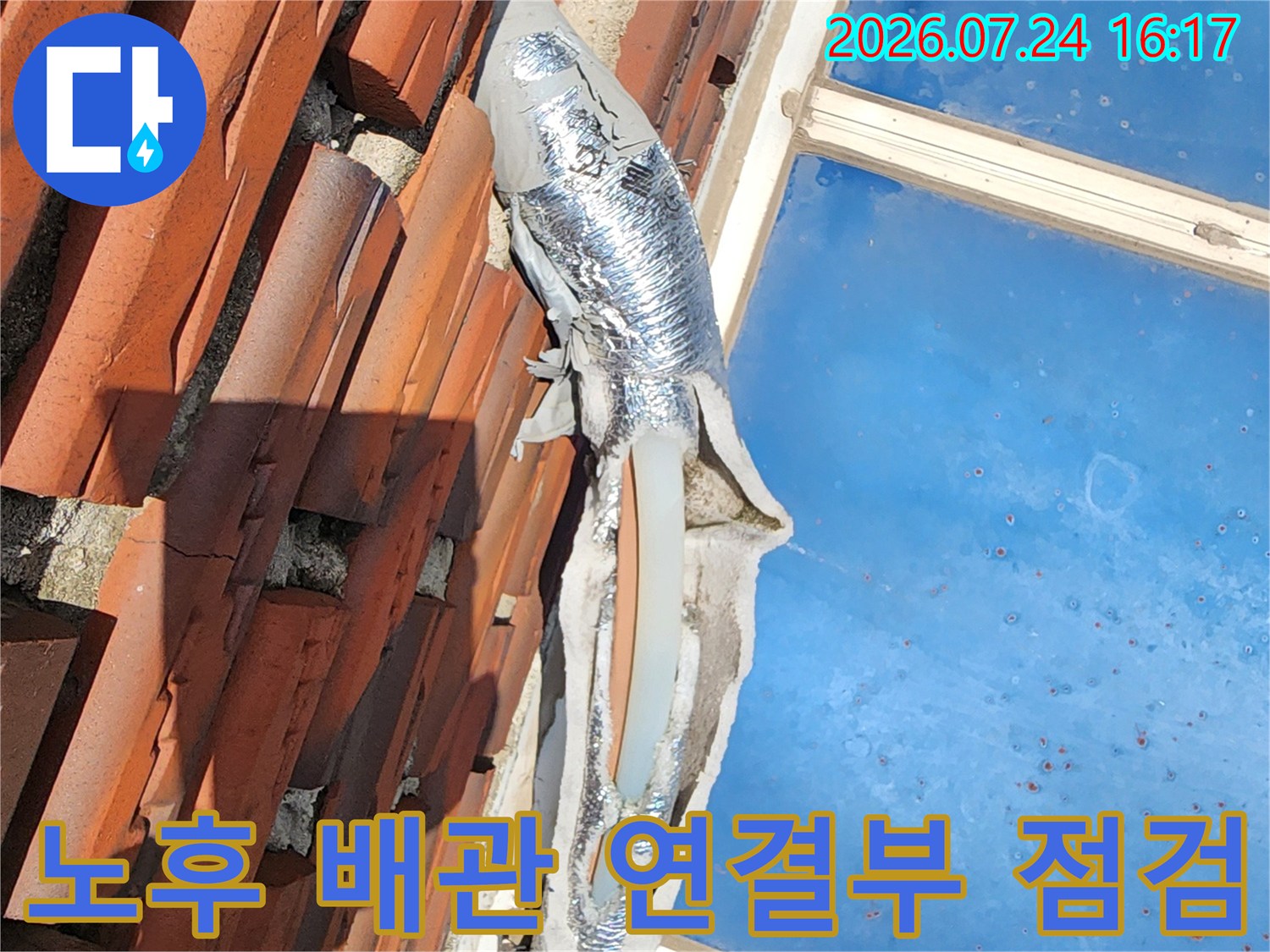 붉은색 외벽 마감재와 파란색 단열재로 덮인 수도배관