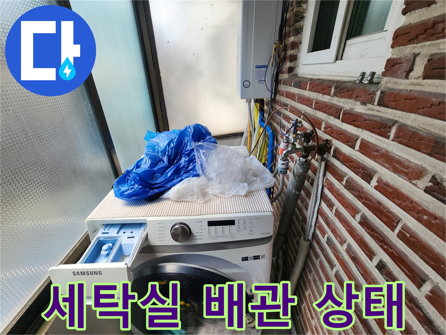 세탁기 옆에 위치한 외부 노출 수도 배관의 모습입니다.