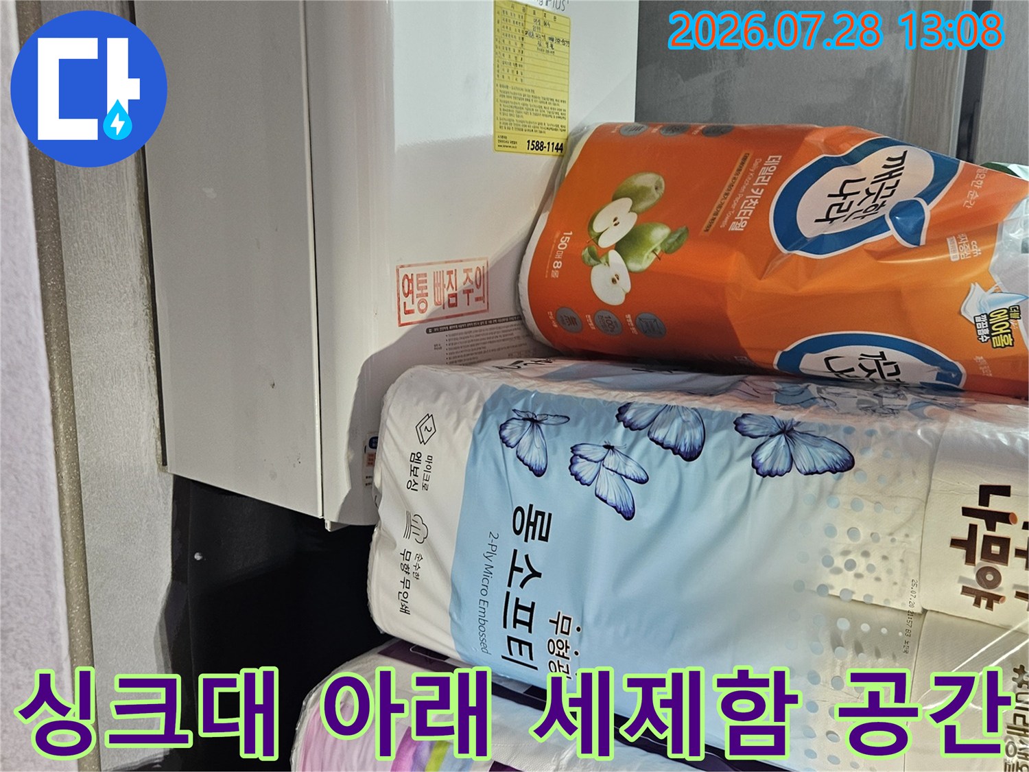 세제 통이 비치된 주방 수납공간 내의 배수 시스템 점검 사진