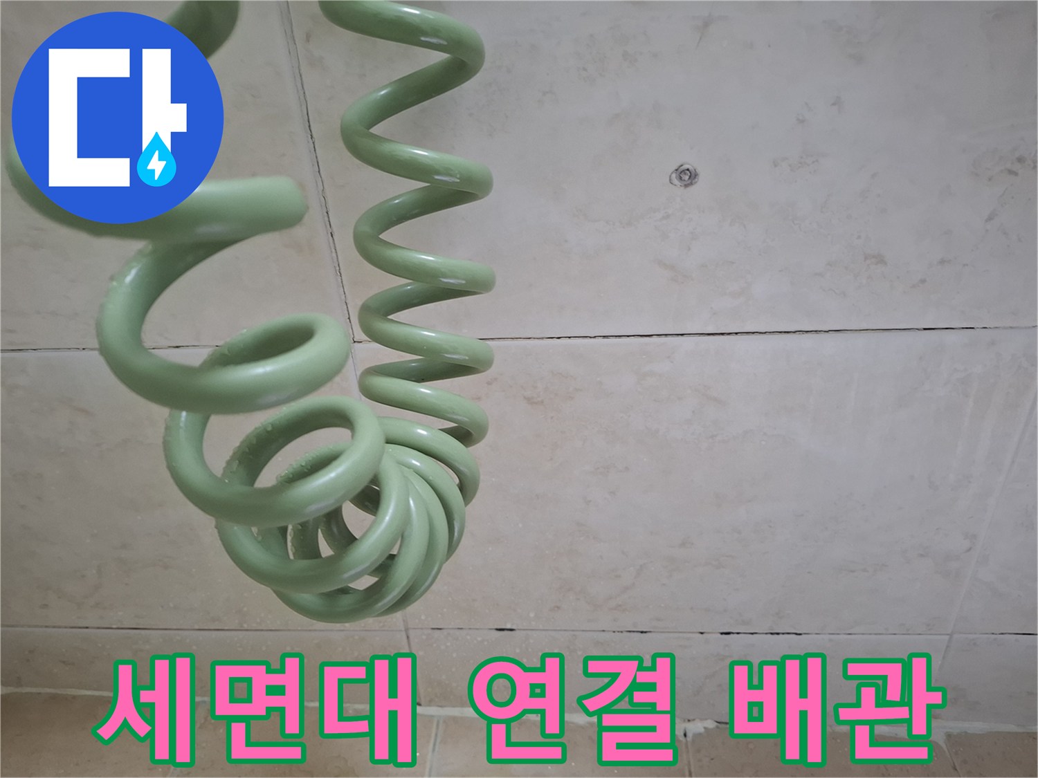 초록색 주름진 배관과 타일 벽면의 접촉 부위