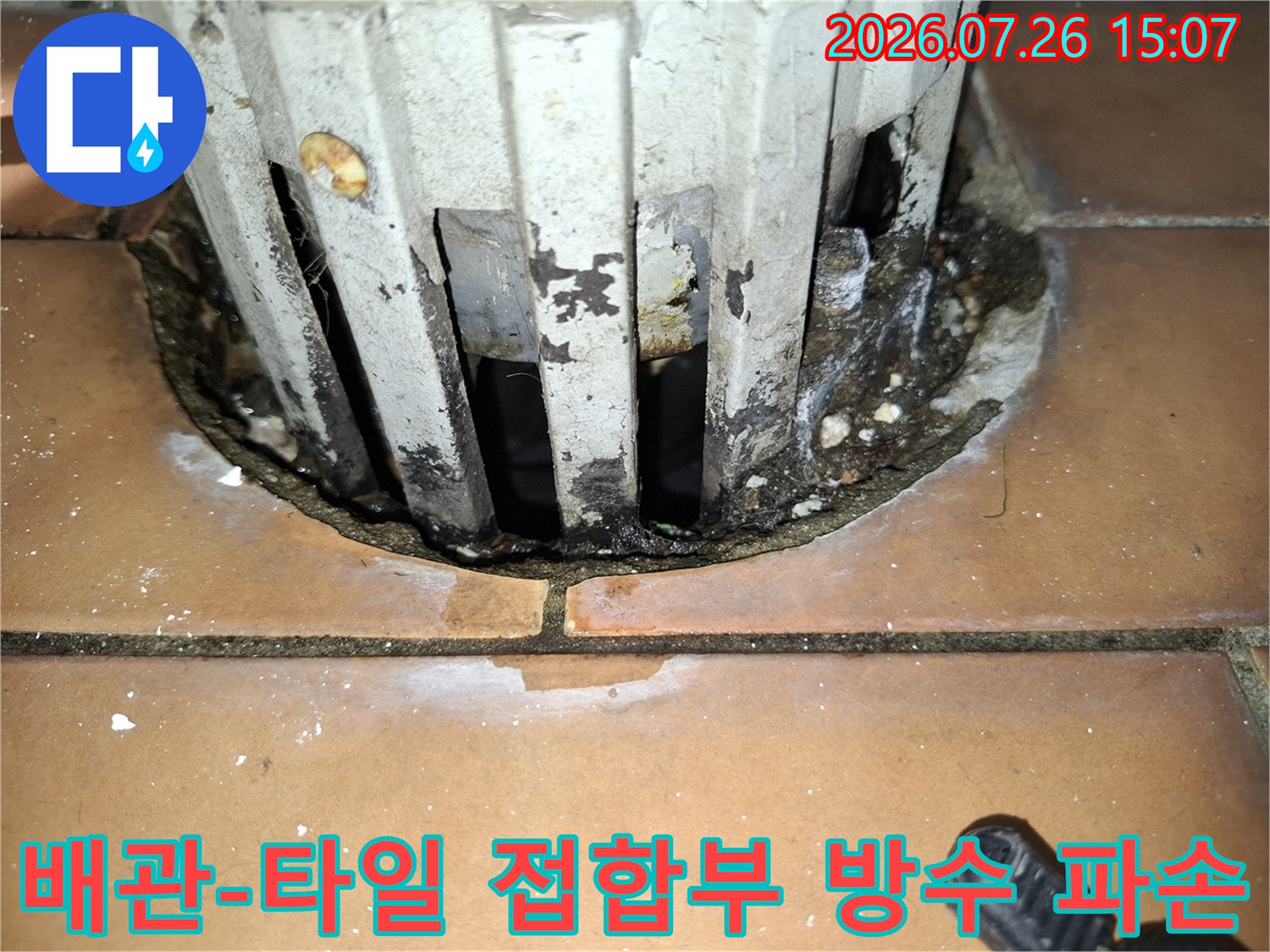 흰색 배관과 갈색 타일 사이의 마감재가 소실되어 검은 틈새가 형성된 모습