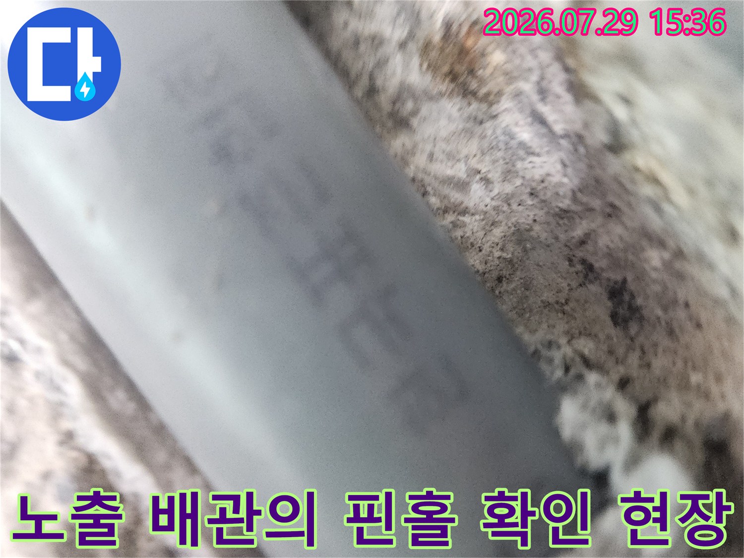 벽체 내부에서 노출된 파손된 회색 배관과 누수 지점 사진