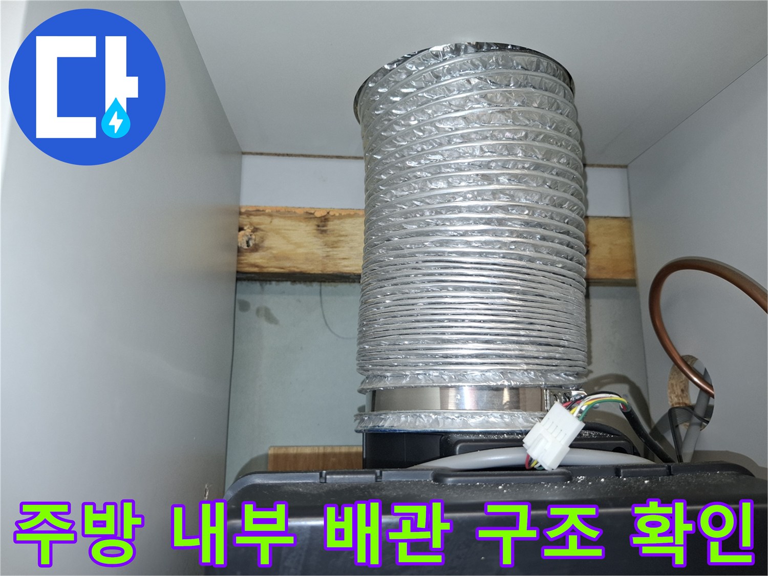 주방 상부장 아래 설치된 은색 호스와 전선 연결 상태를 보여주는 사진