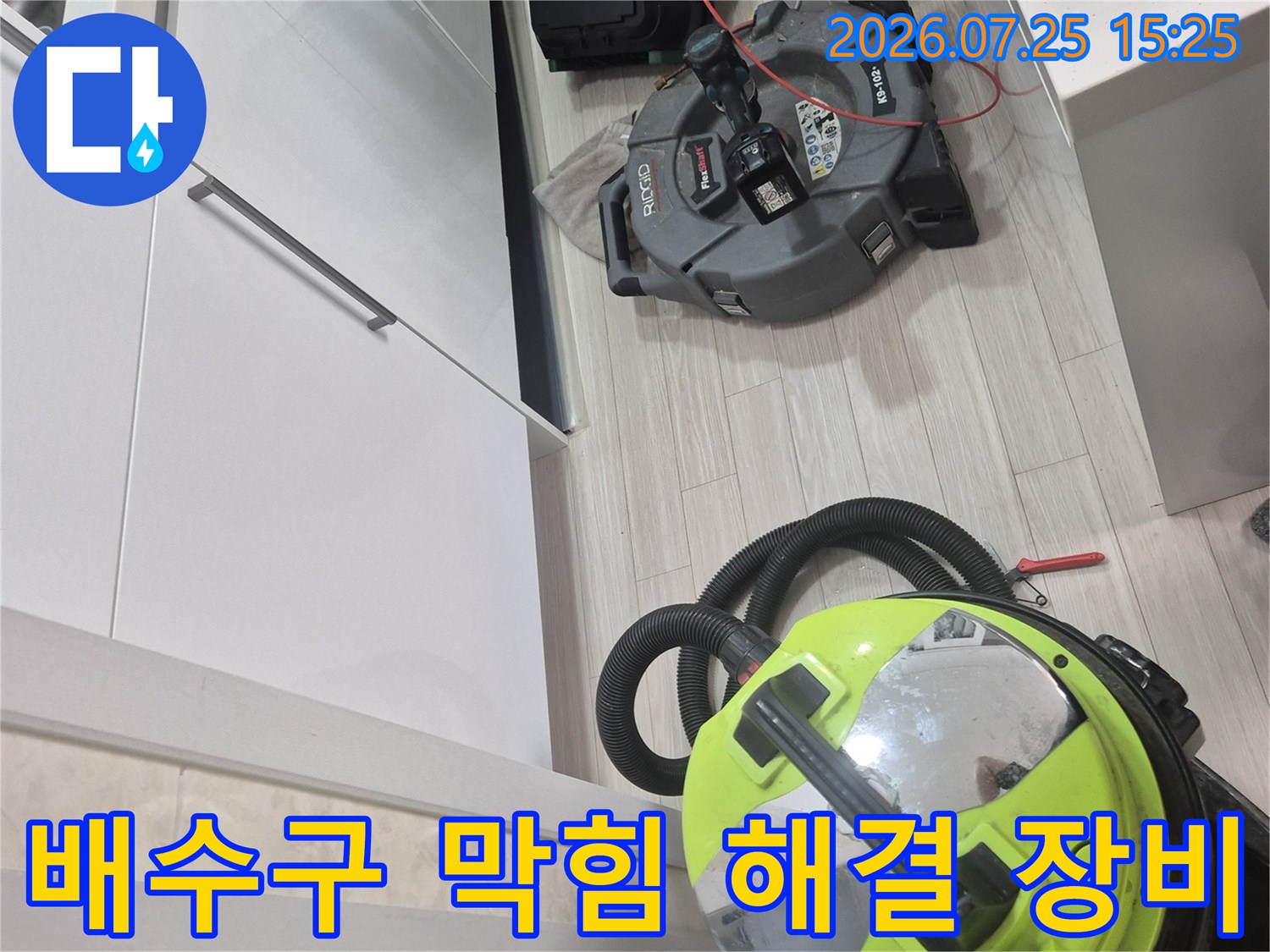 주방 하부장 내부에 설치된 대형 석션기와 배관 세척을 위한 보조 장치