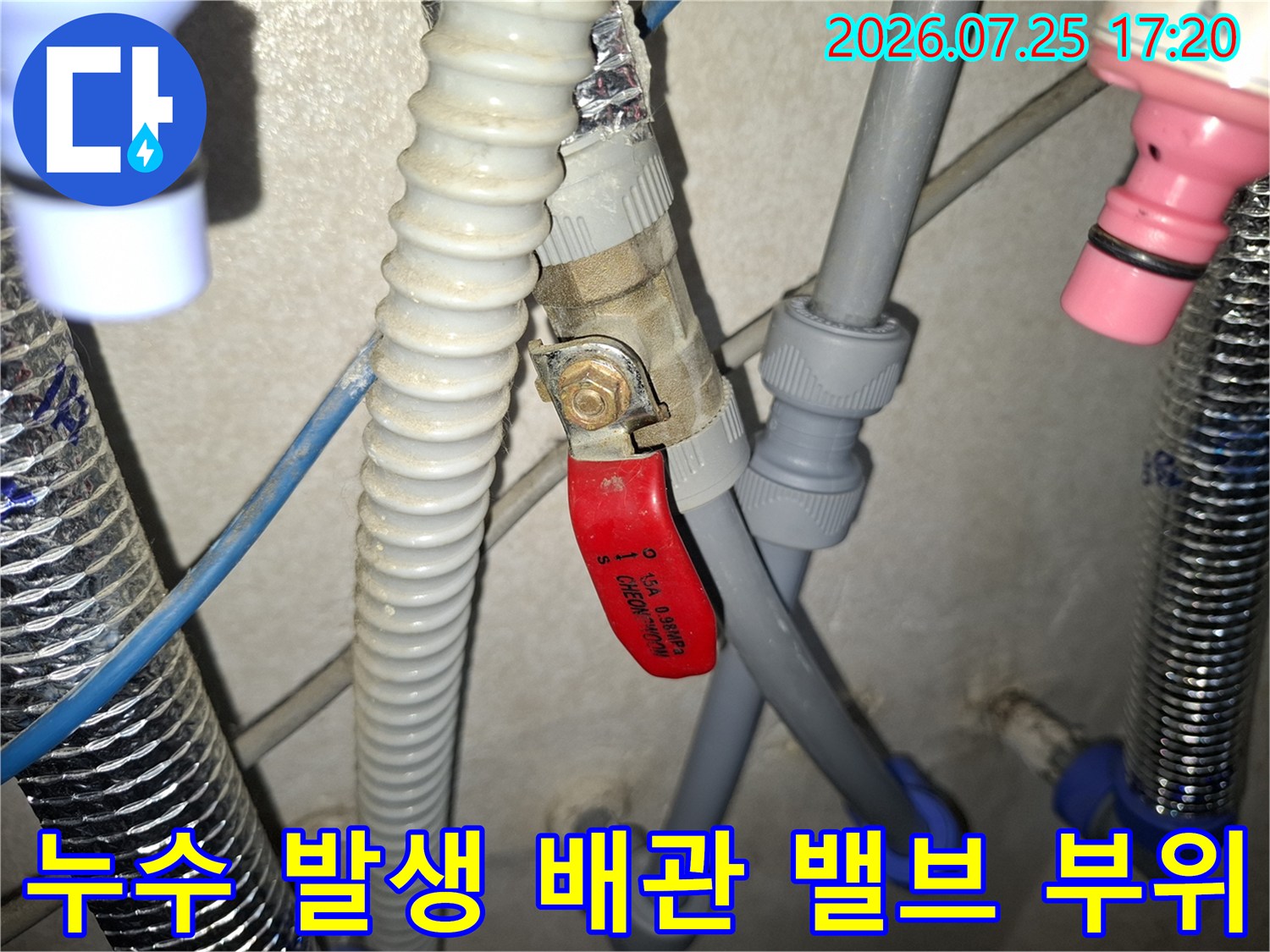 삼성 표기가 된 회색 플라스틱 배관과 빨간색 조절 밸브의 연결 상태