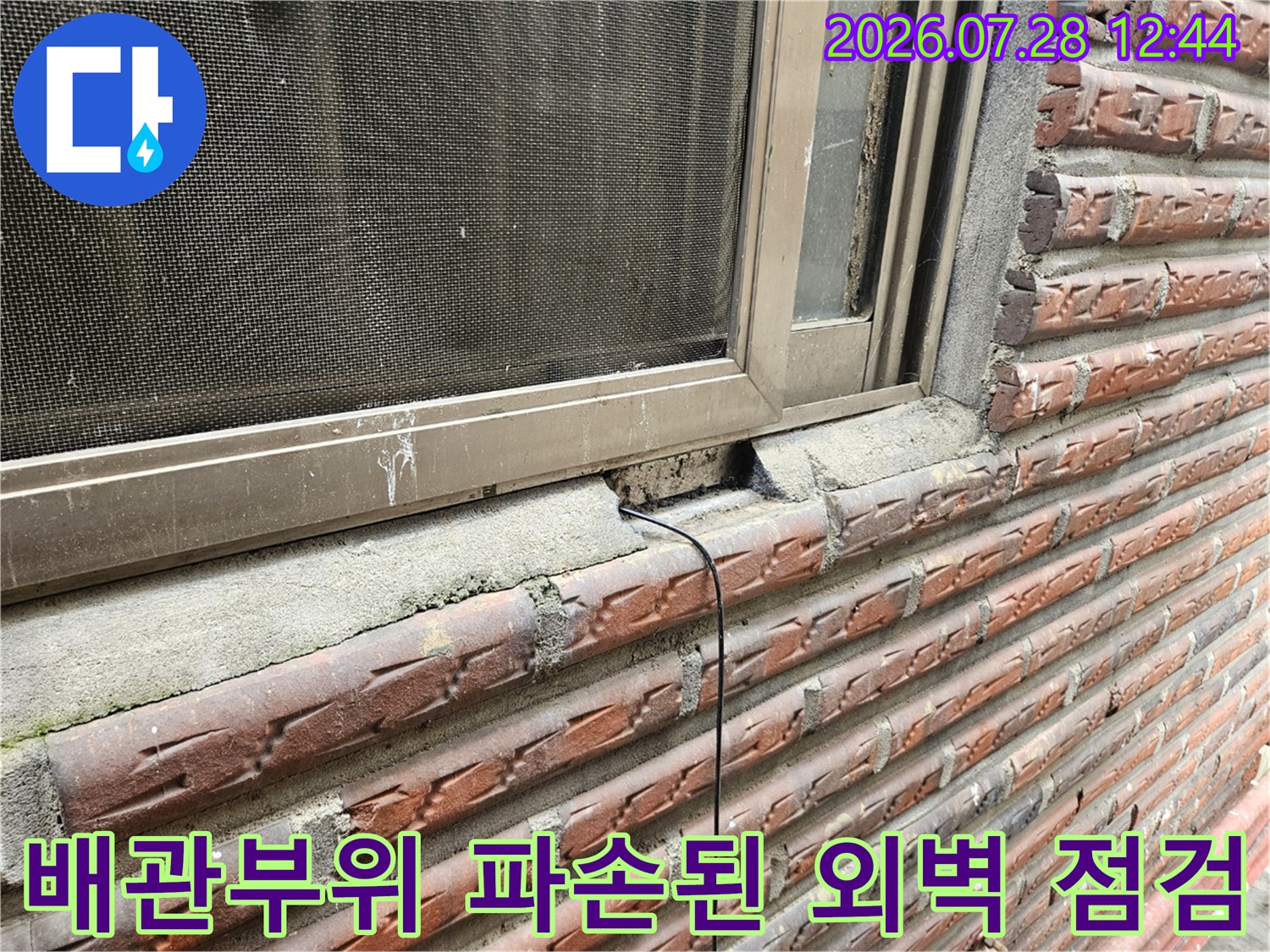 창문 하단 배관 연결 부위와 균열이 발생한 벽면을 근접하여 촬영한 사진