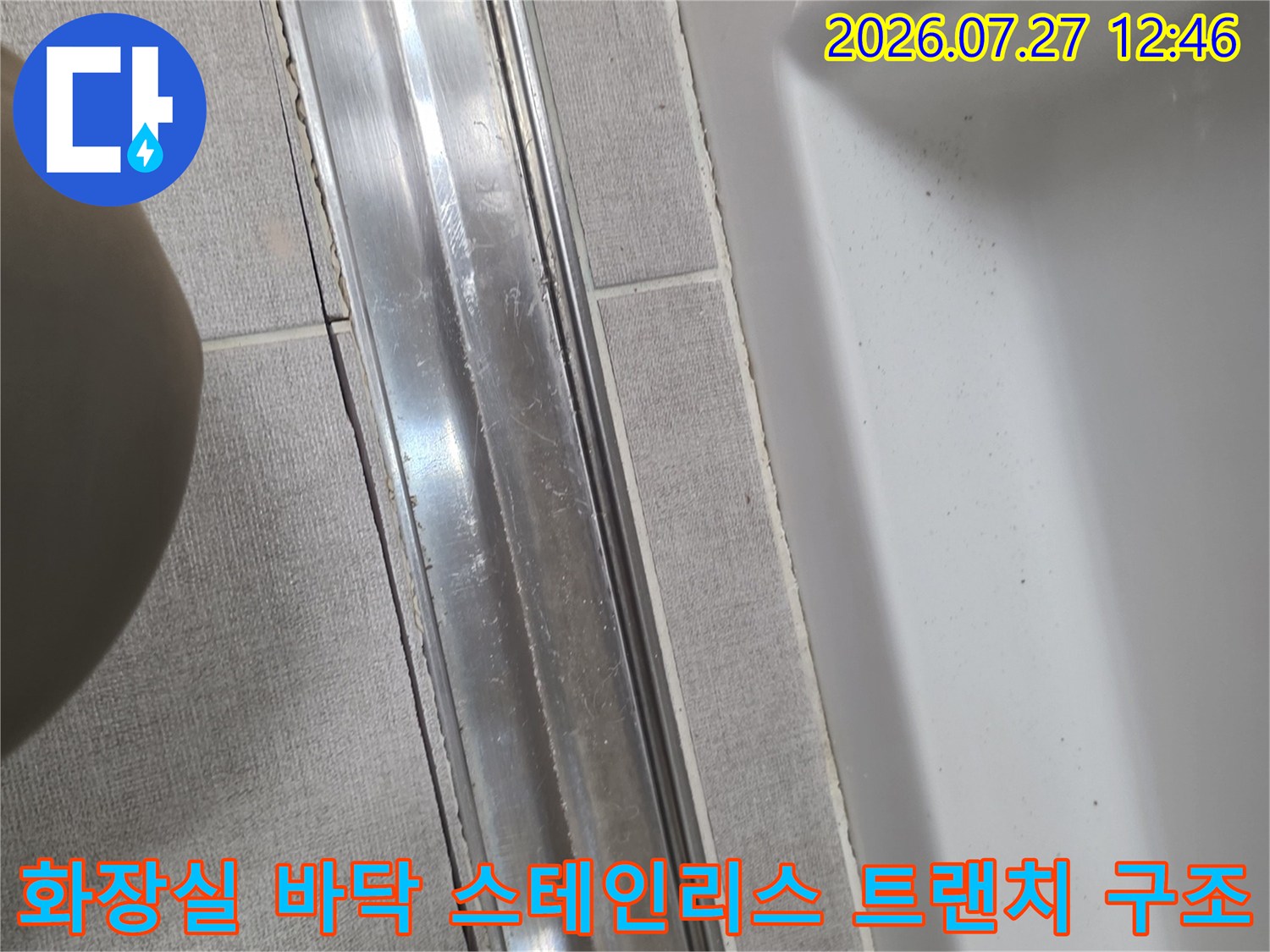 회색 타일 사이에 매립된 은색 금속제 직선형 하수구-트랜치 사진