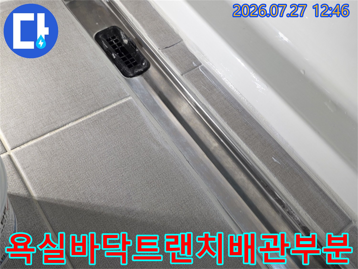 회색-타일과-금속제-트랜치가-만나는-경계면의-배수구-모습
