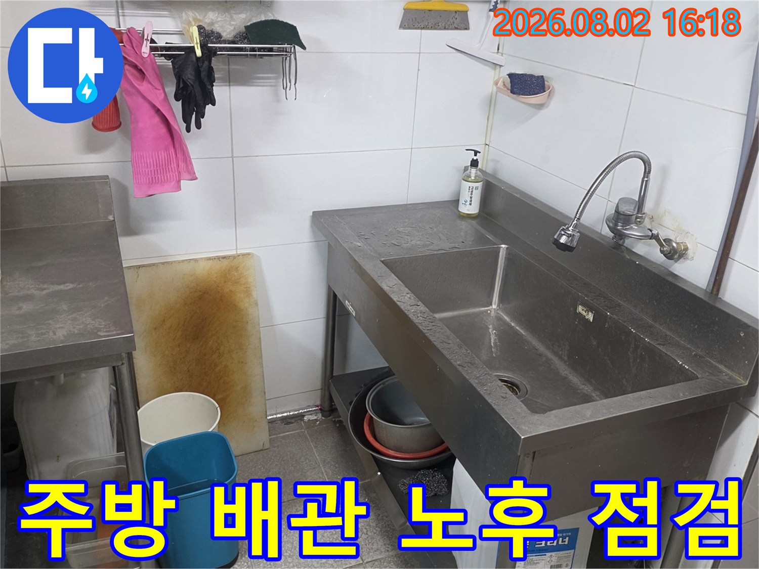 싱크대 하부 스테인리스 구조물과 연결된 배관들