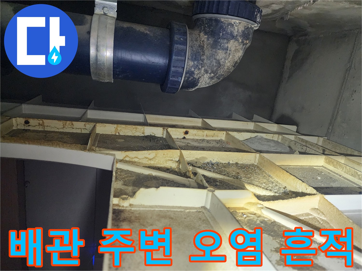 천장 배관 하단에 형성된 어두운색의 물샘 흔적과 습기
