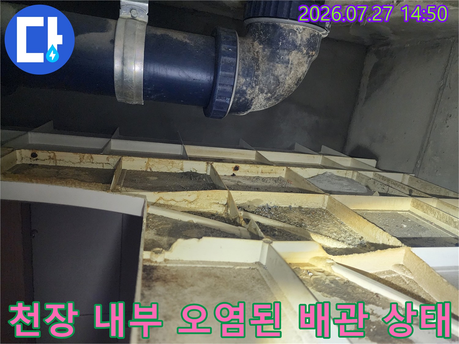 화장실 천장 점검구 내부-오염된 판넬과 파란색 배수 배관 모습