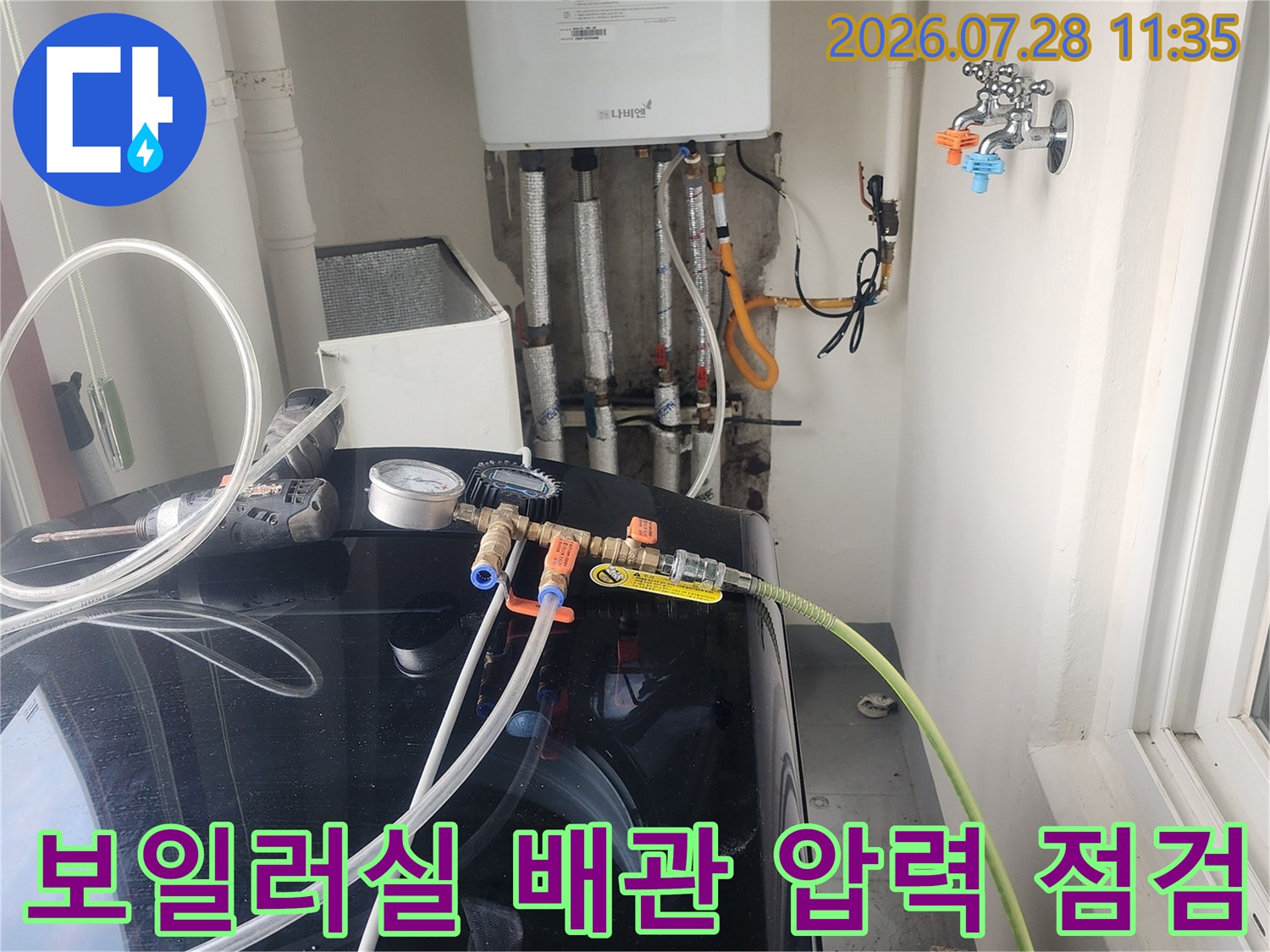 검은색 기기 옆에 연결된 노란색과 초록색 배관을 대상으로 공압 시험을 진행하는 현장 모습