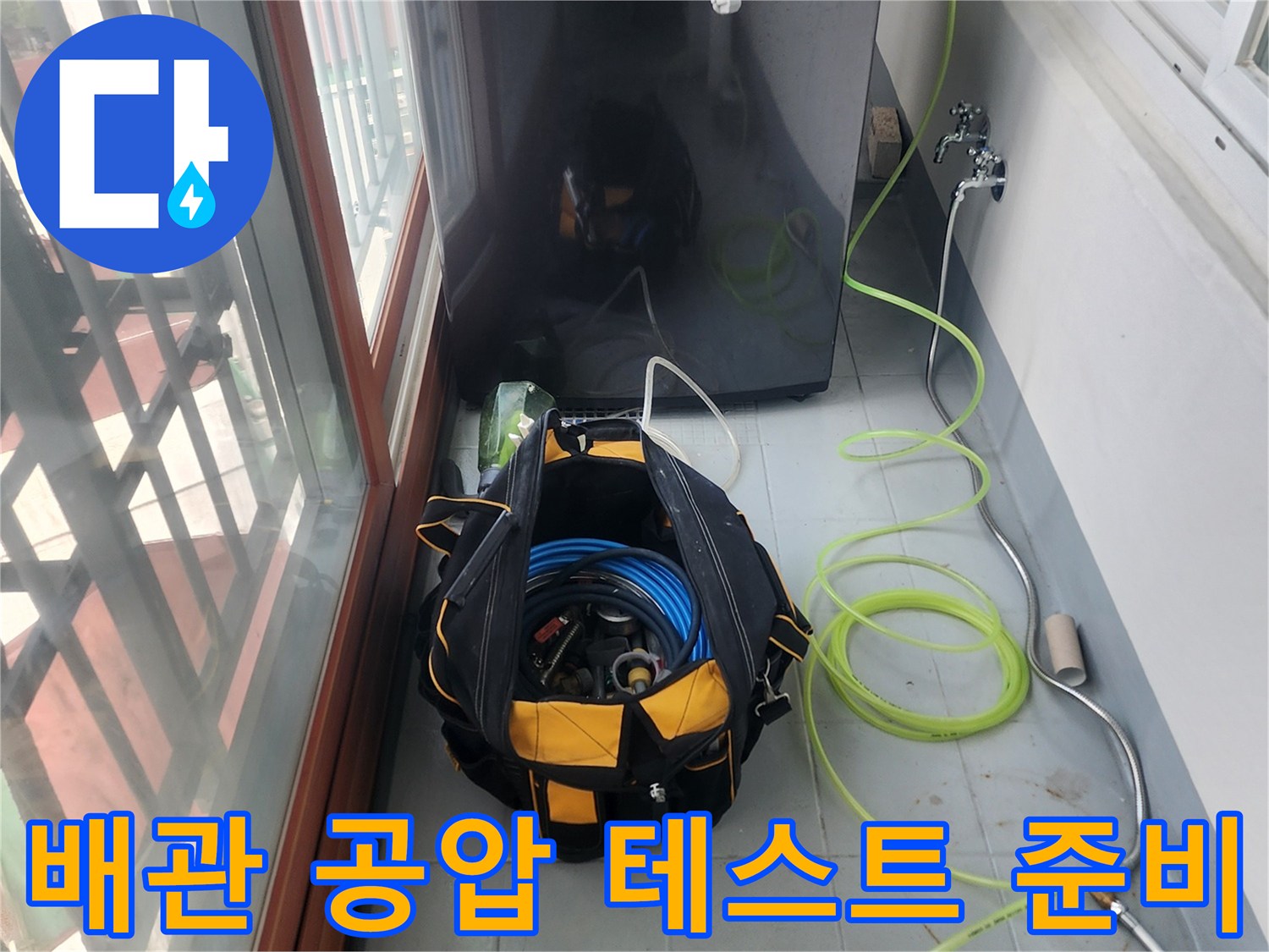세탁실 바닥에서 진행 중인 배관 압력 검사 및 장비 세팅