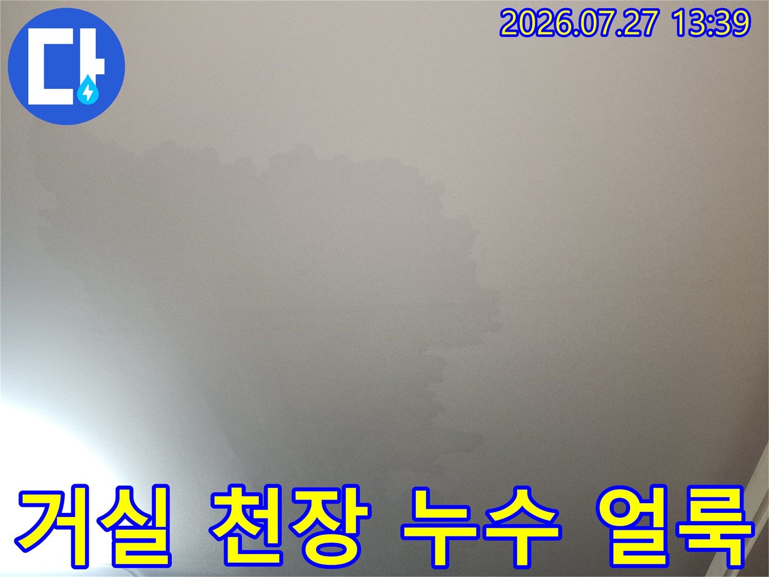 거실 천장의 하얀 마감재 위로 물이 스며들어 발생한 넓은 변색 부위-누수 피해 현장