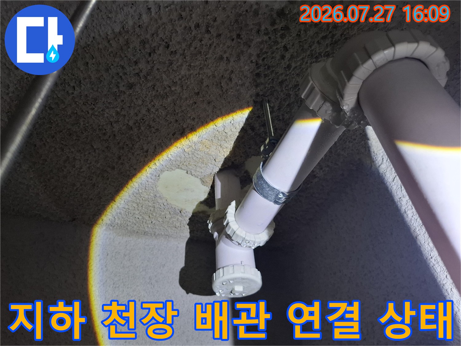 지하층 천장에 설치된 흰색 플라스틱 배관과 엘보우 연결 부위-상태 점검 모습