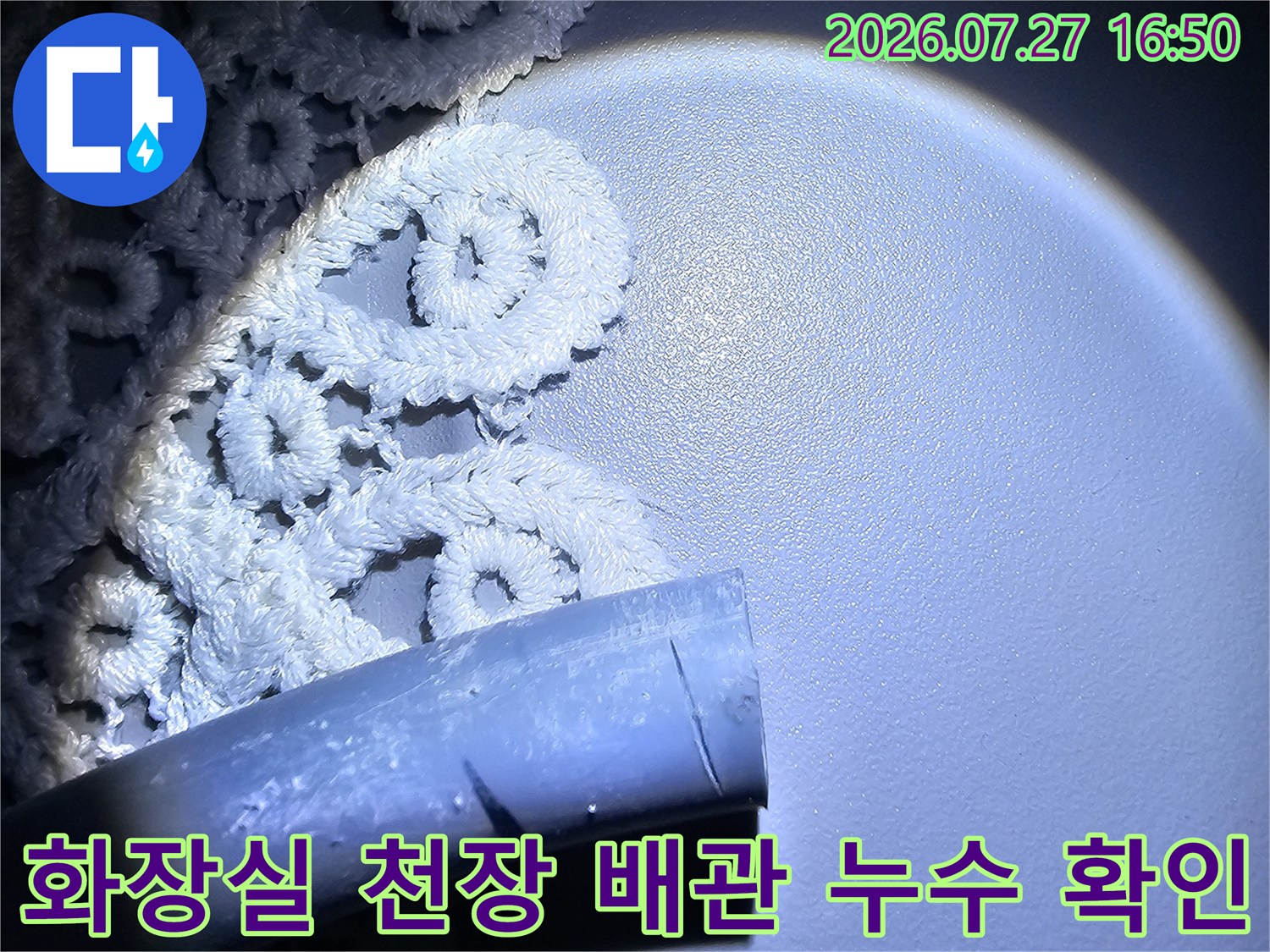 어두운 화장실 천장에서 내시경 카메라 조명으로 비춘 파손된 배관 모습