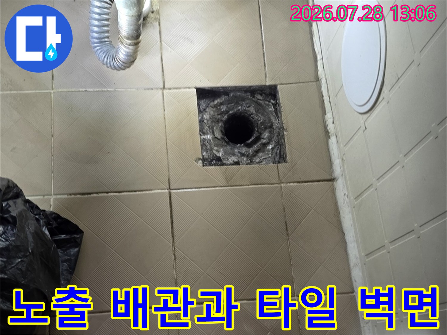 욕조 밑쪽으로 노출된 배관 부위와 주변 타일 마감 상태를 촬영한 사진