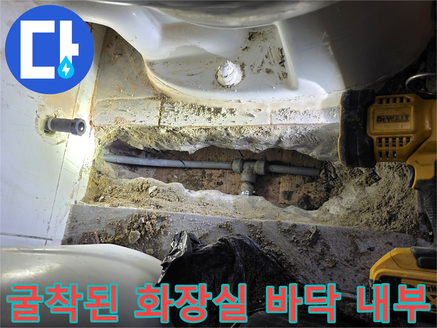 변기 아래쪽 흙 속에 드러난 부식된 배관 연결부