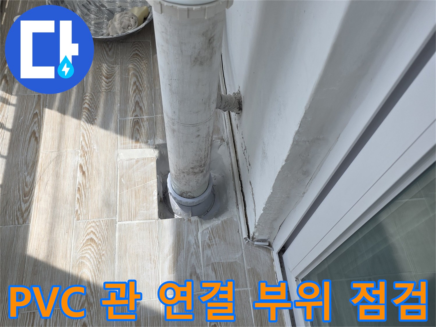베란다 배수관의 연결 상태와 주변 마감재를 보여주는 사진입니다.