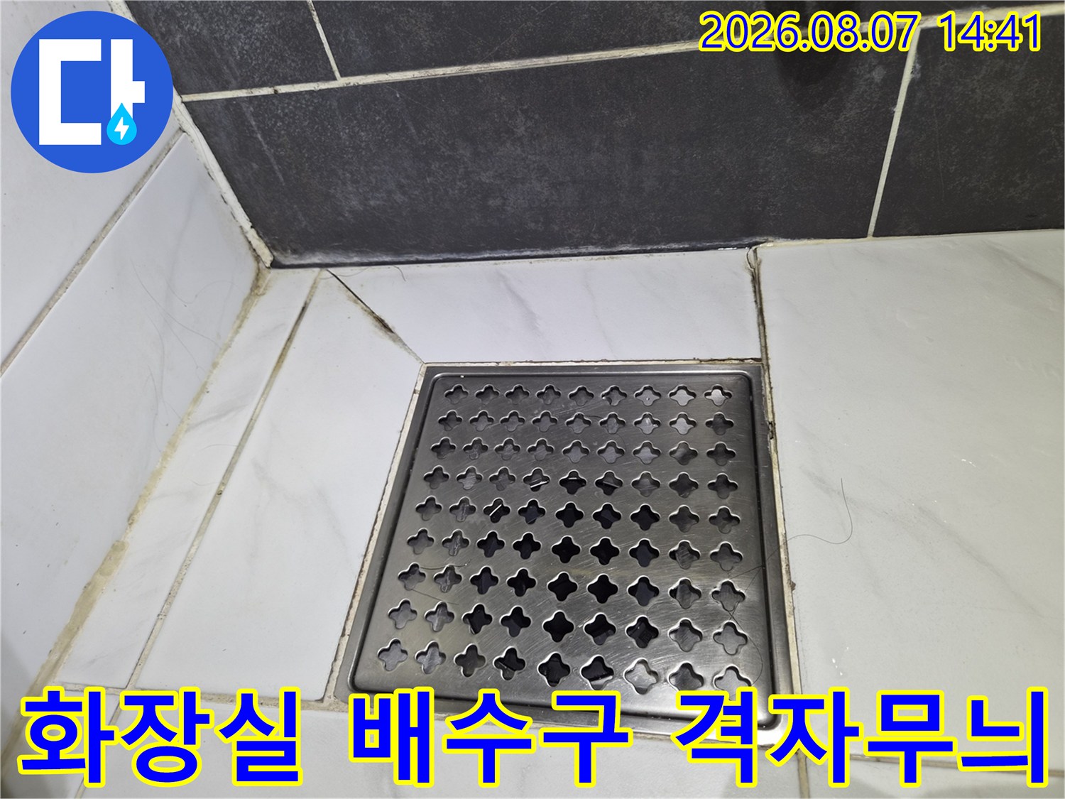 금속제 배수구 덮개와 주변 타일의 접합 부위 사진입니다.