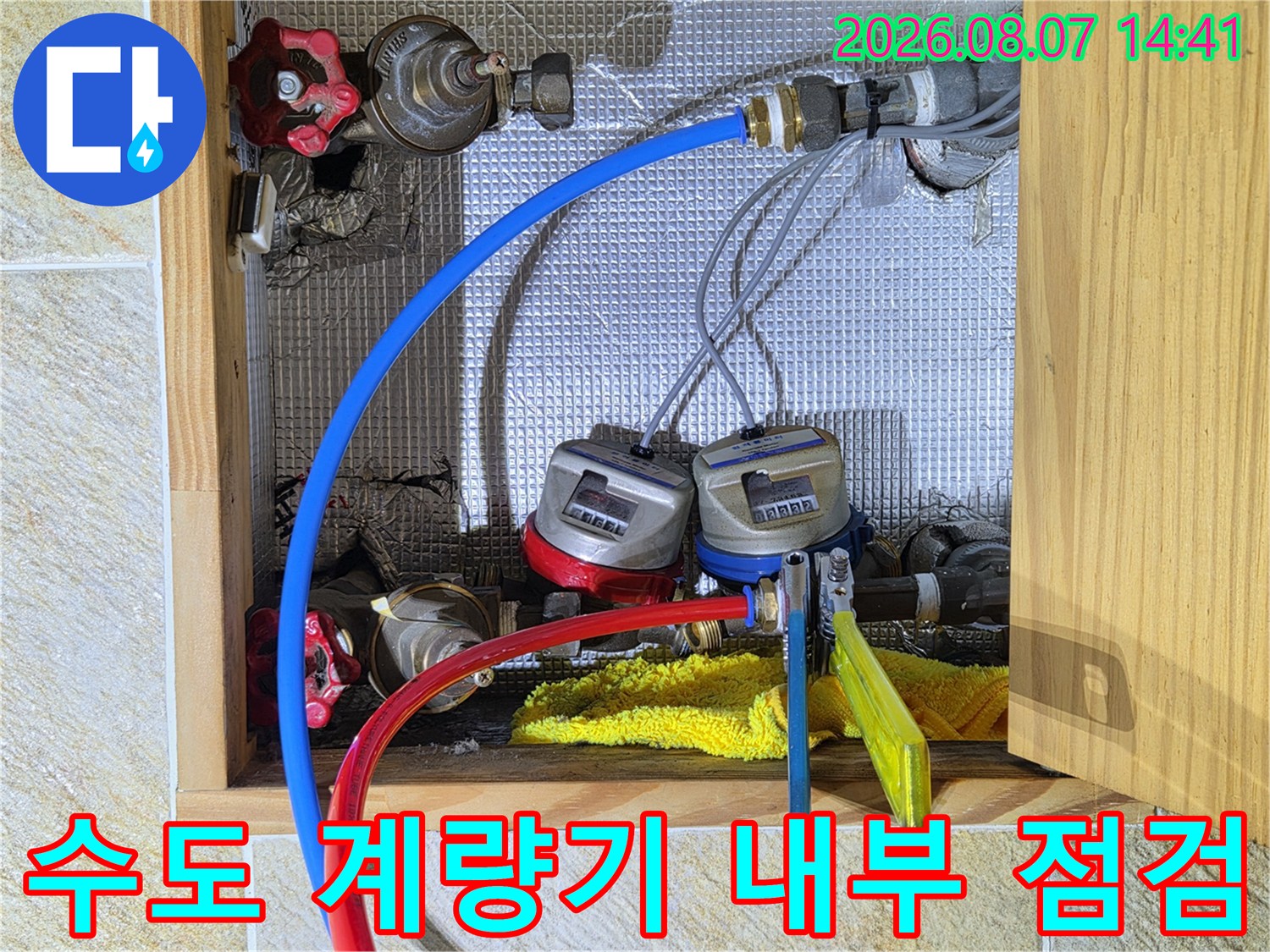 수도 계량기에 연결된 호스와 밸브를 통한 배관 압력 테스트 장면입니다.