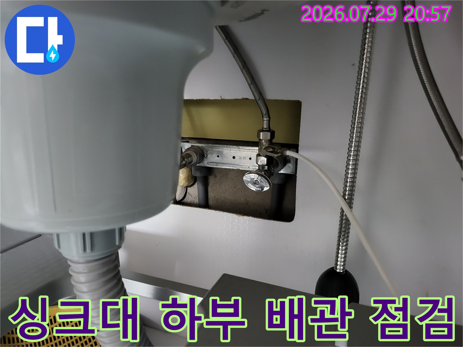 싱크대 아래쪽 노출된 온수 배관과 분배기 연결 부위 점검 장면