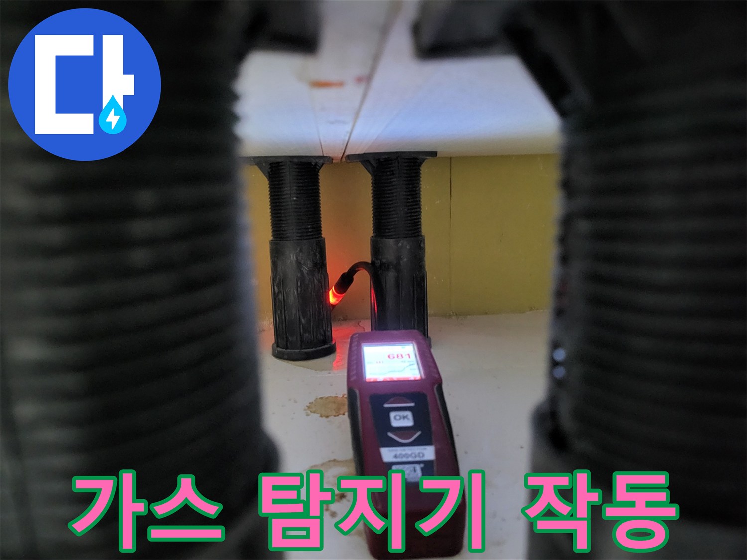 싱크대 하단 배관 부근에서 가스 탐지기를 사용하여 누수 지점을 찾는 모습입니다.