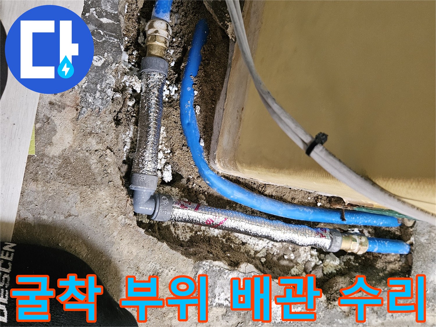 노출된 파란색 배관과 금속 연결 부속의 보수 작업 사진