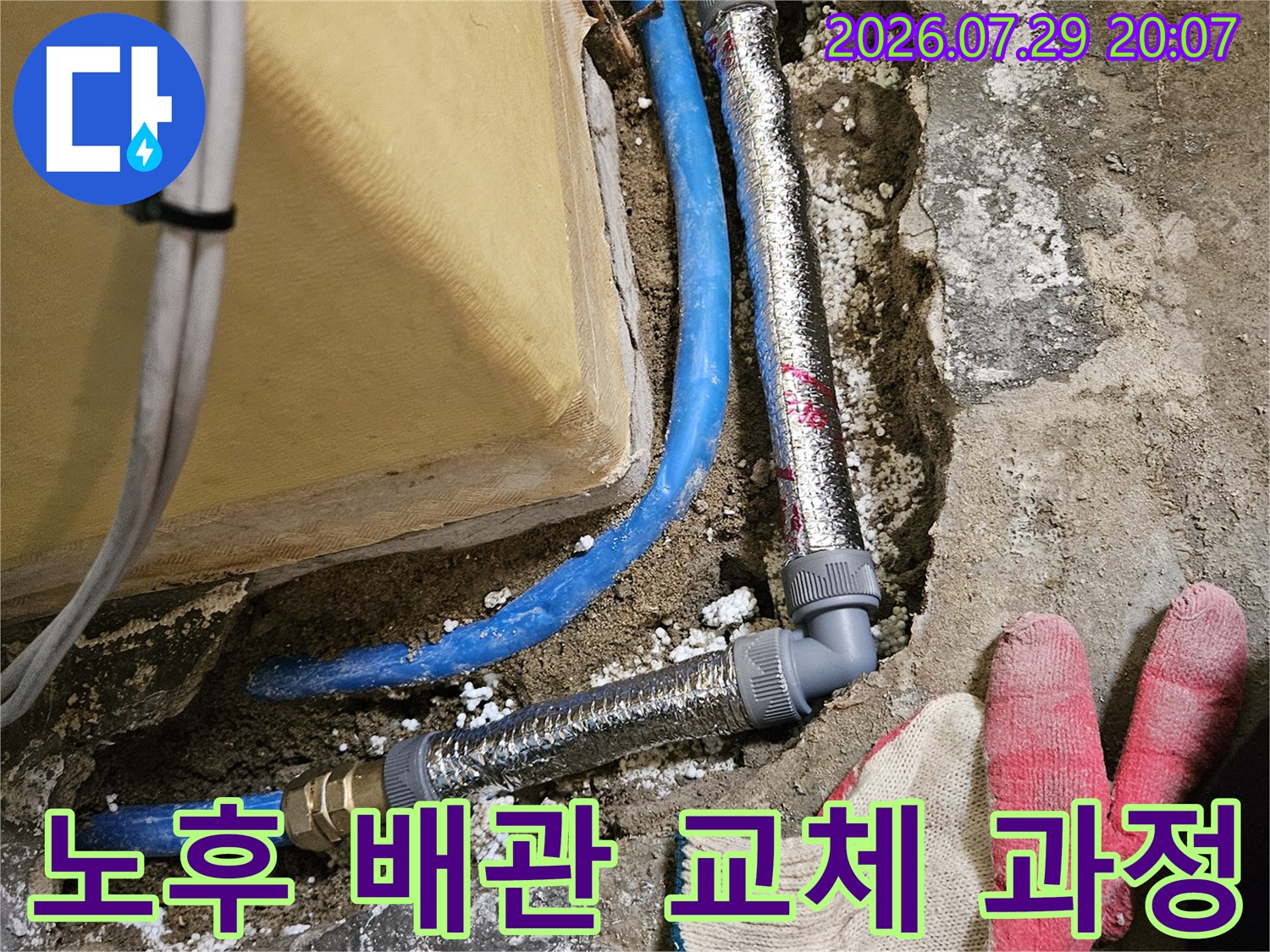 파란색 온수 배관을 새 자재로 연결하는 보수 공사 장면