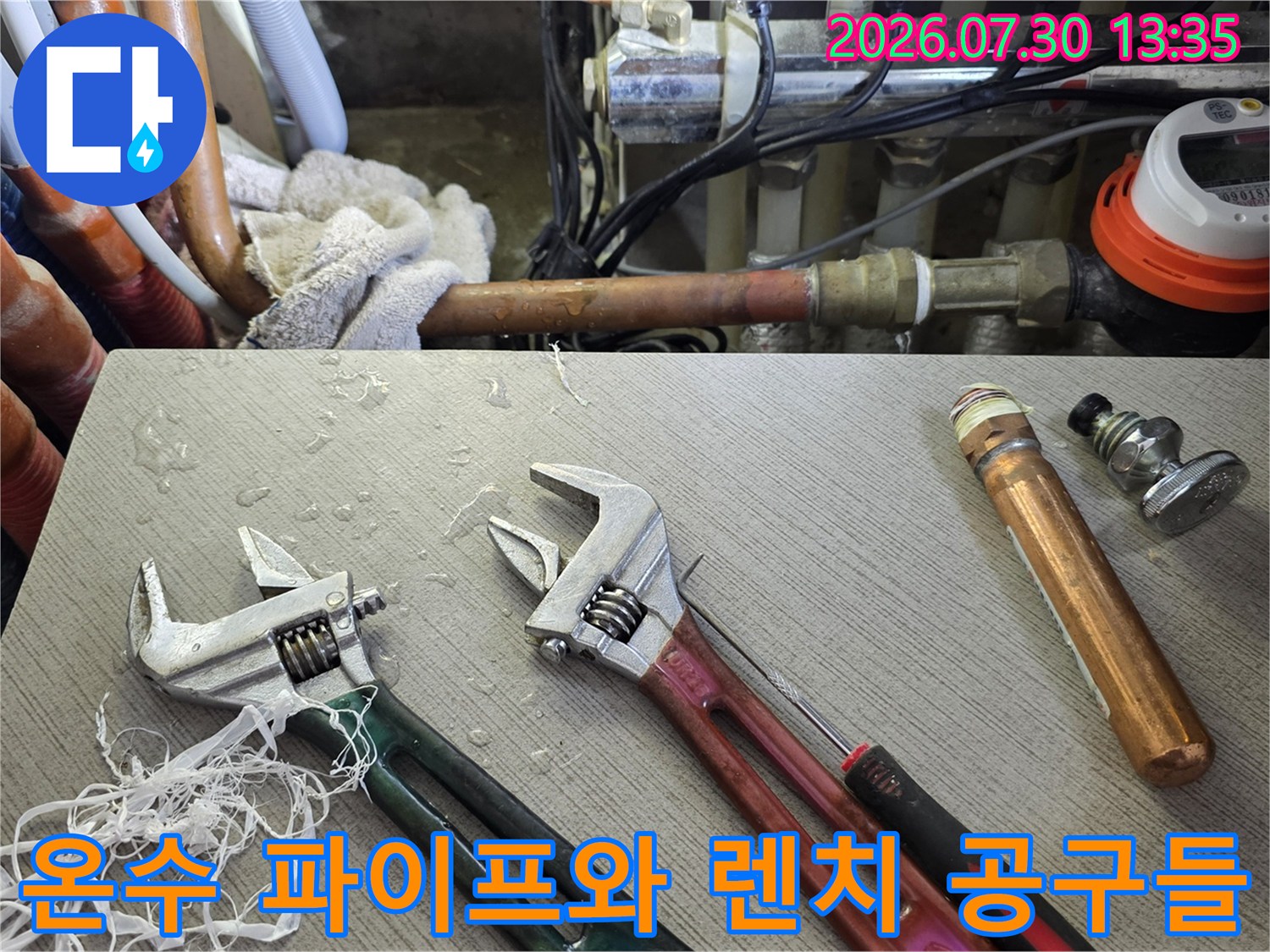 온수 배관과 연결용 몽키스패너가 배치된 작업 현장