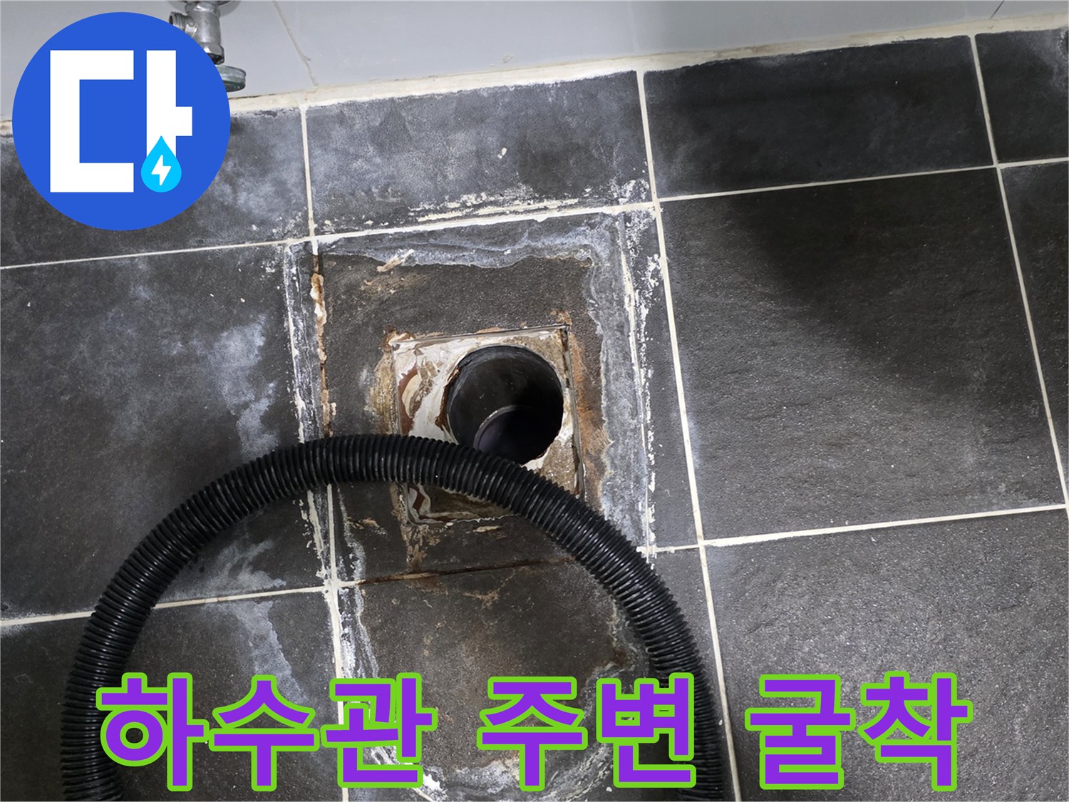 타일 아래 노출된 하수구 배관과 주변부 상태