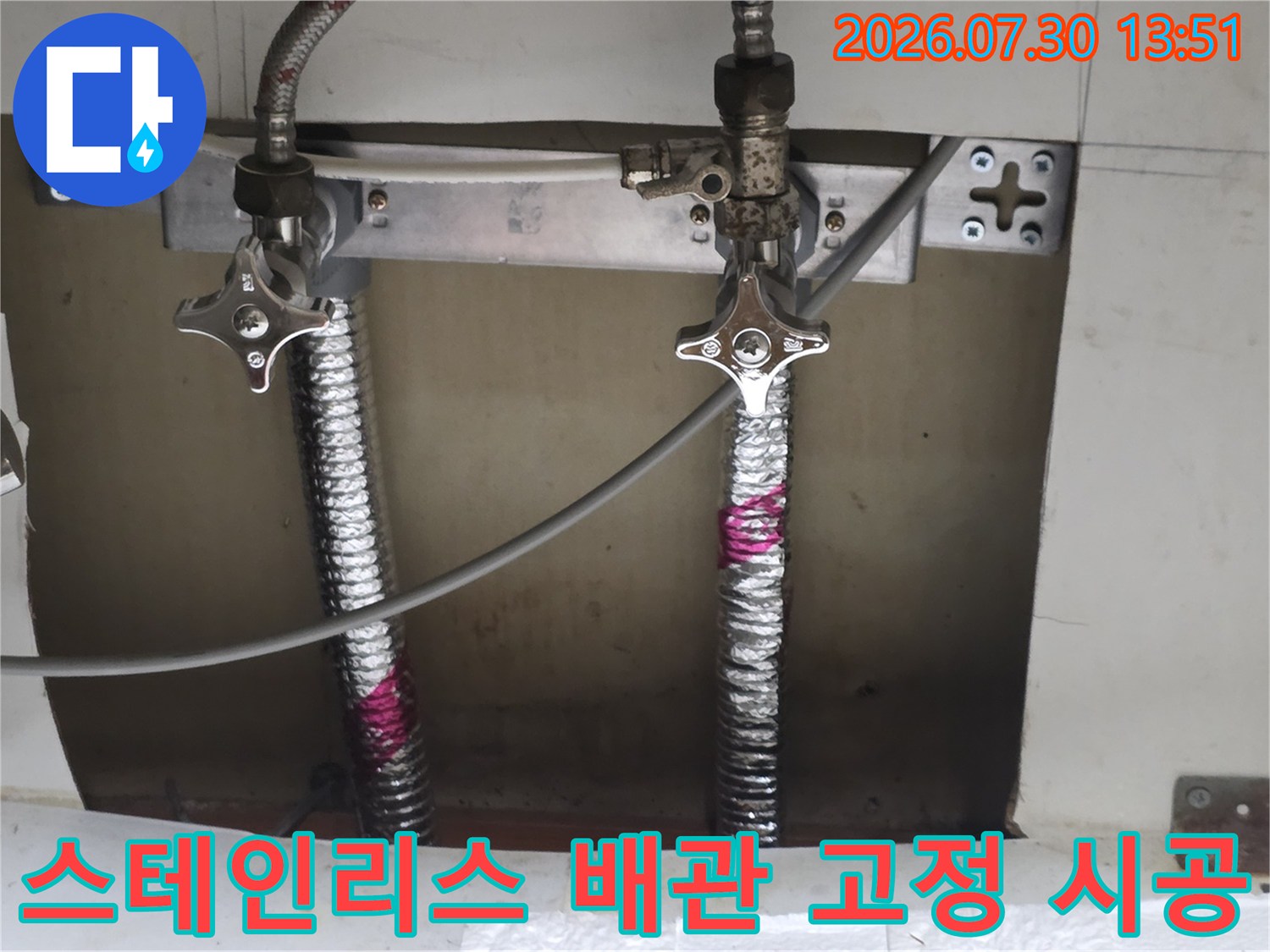 싱크대 하부 공간에 스테인리스 주름배관과 금속 브래킷을 사용하여 견고하게 고정한 모습