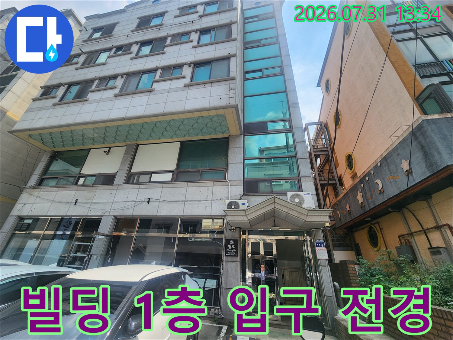 입구에 위치한 상가 건물과 안내 표지판