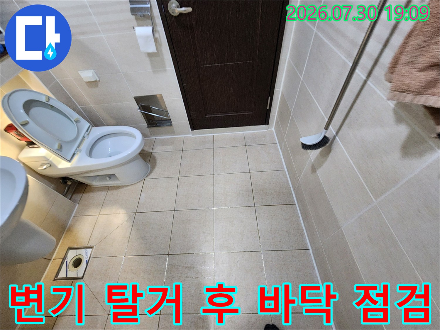 탈거된 변기 아래 노출된 타일과 배수관 주변을 상세히 조사하는 사진