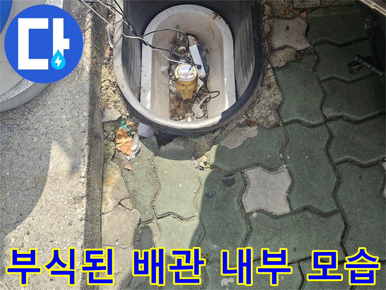 계량기함 내부에 노출된 부식된 금속 배관과 오염된 토사