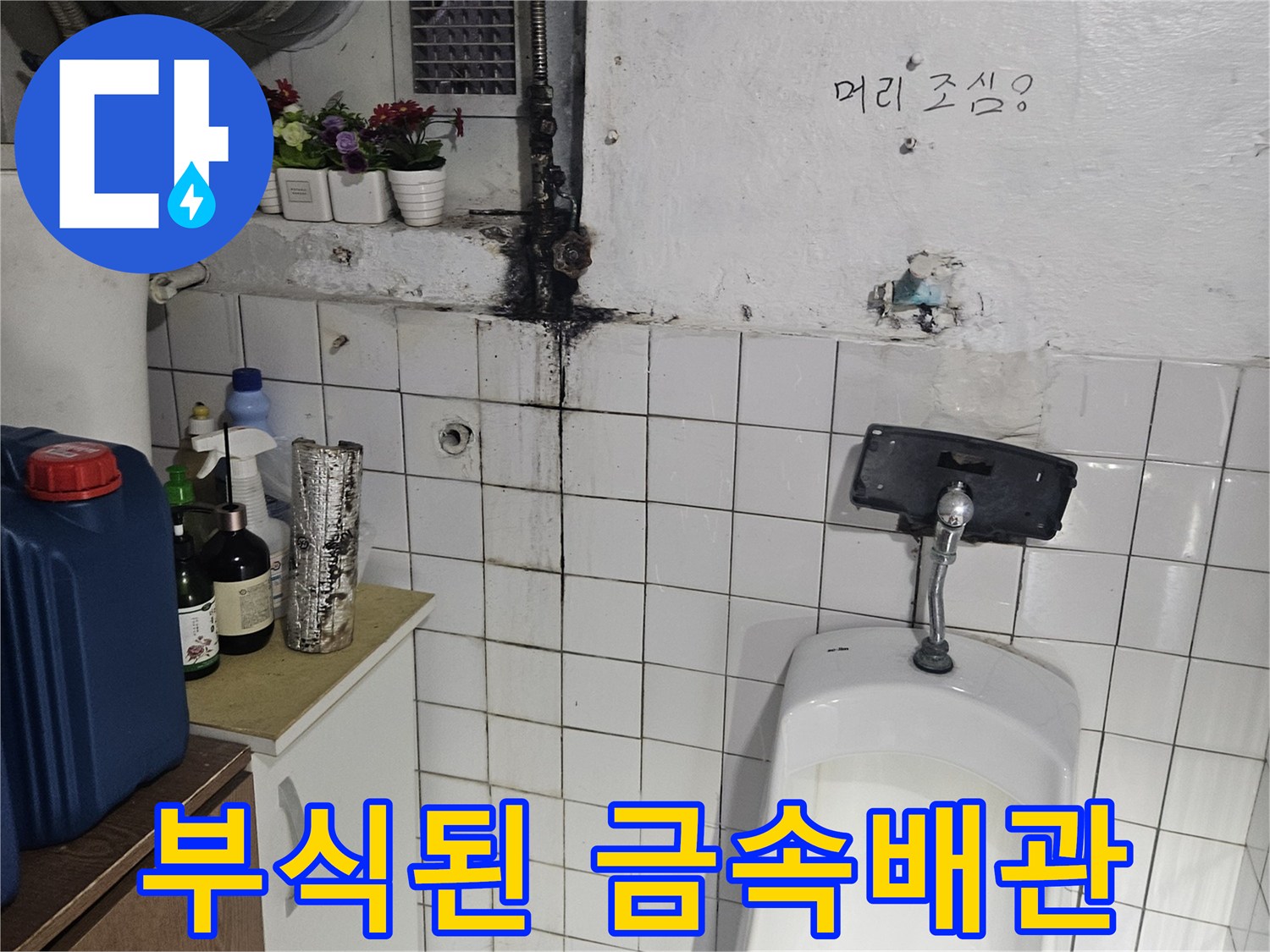 소변기에 연결된 노후된 금속 배관의 부식 상태를 근접 촬영한 사진