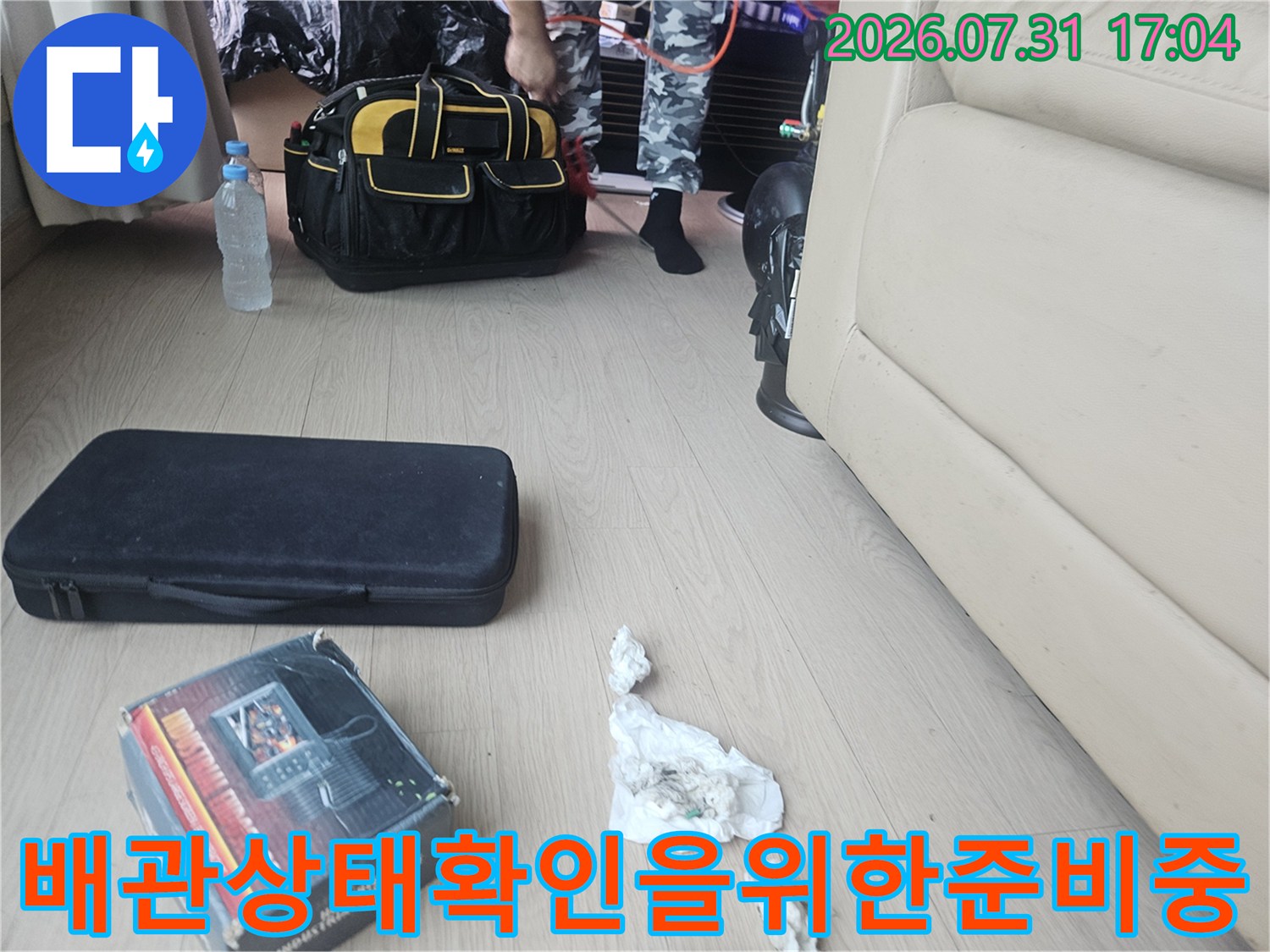 작업용 가방과 소품이 놓인 거실 공간의 작업 준비 모습