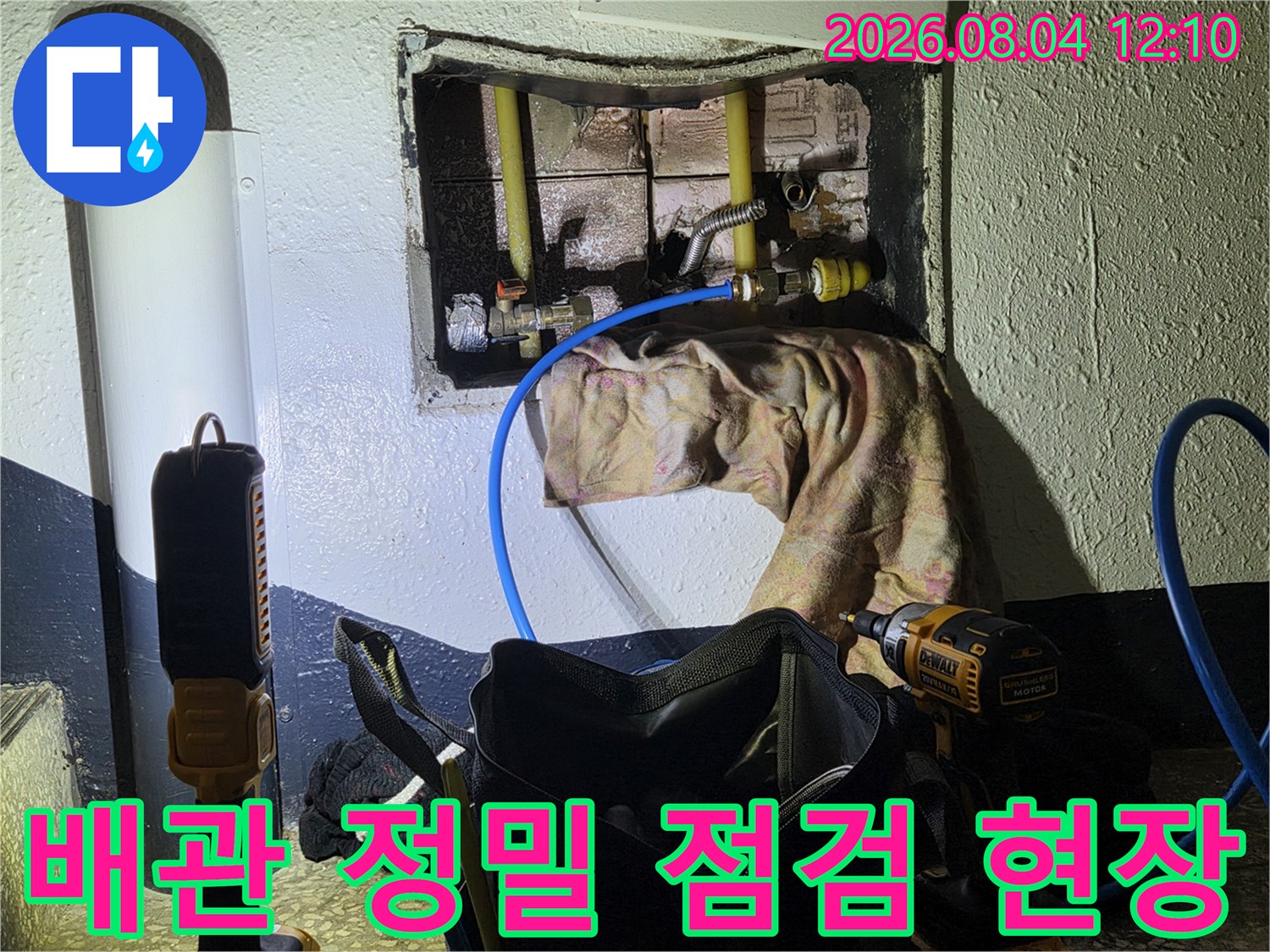 벽면을 굴착하여 노출된 배관과 전문 장비를 배치한 누수 점검 모습
