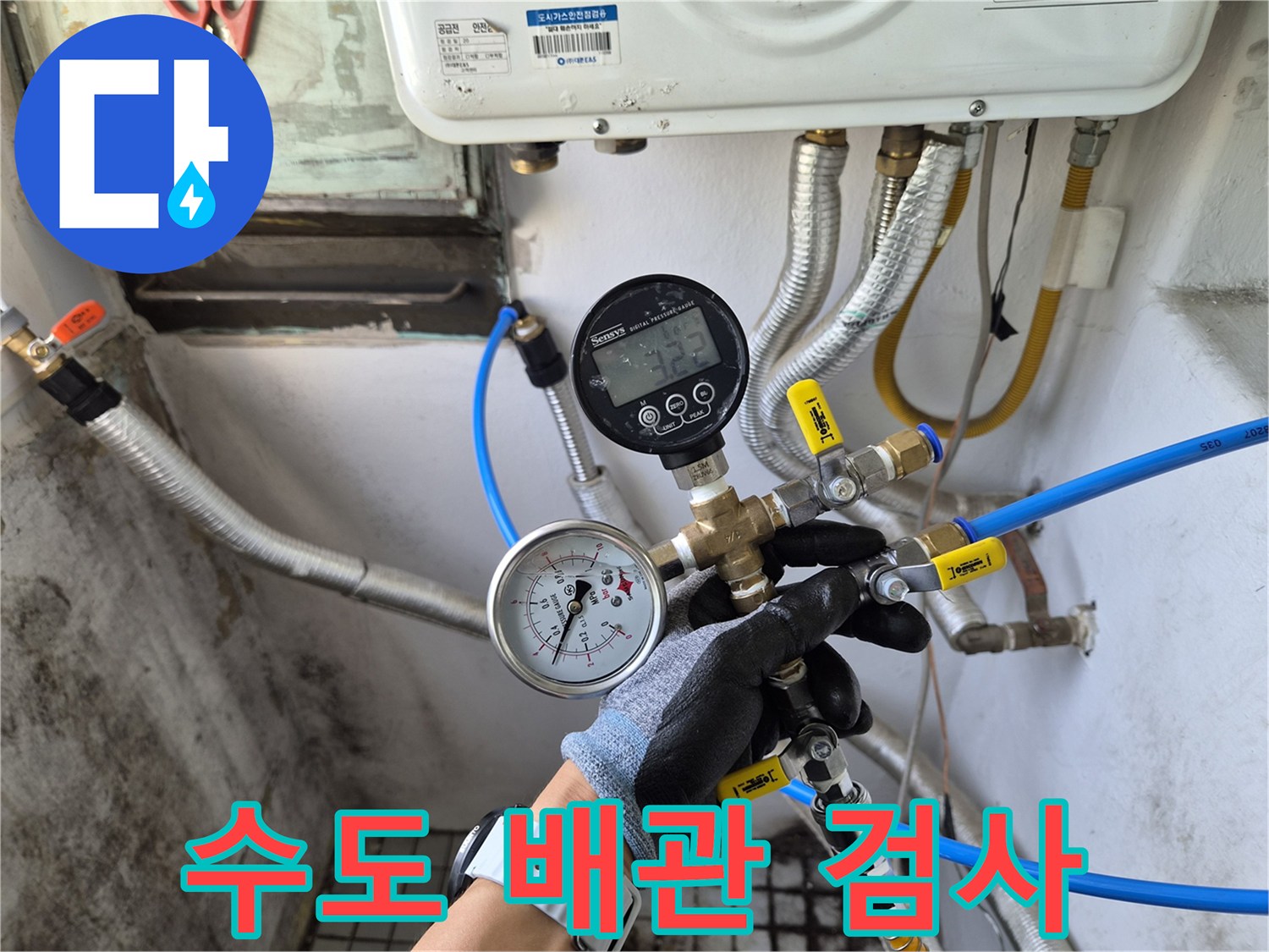 수도 배관 연결 부위에 장착된 압력 게이지와 호스