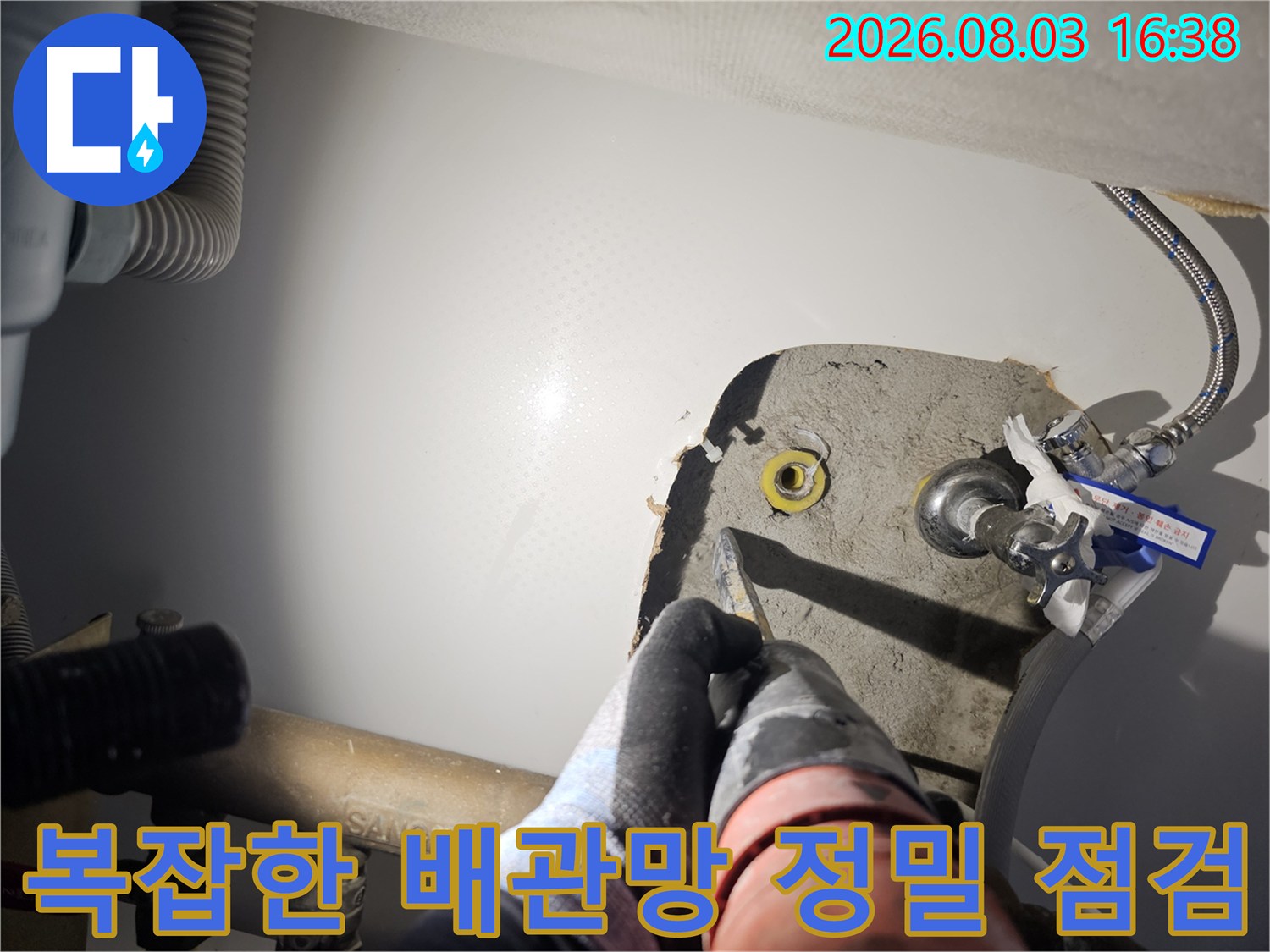 싱크대 아래 설치된 여러 가닥의 배관 중 누수 발생 가능 지점을 집중적으로 분석하는 모습