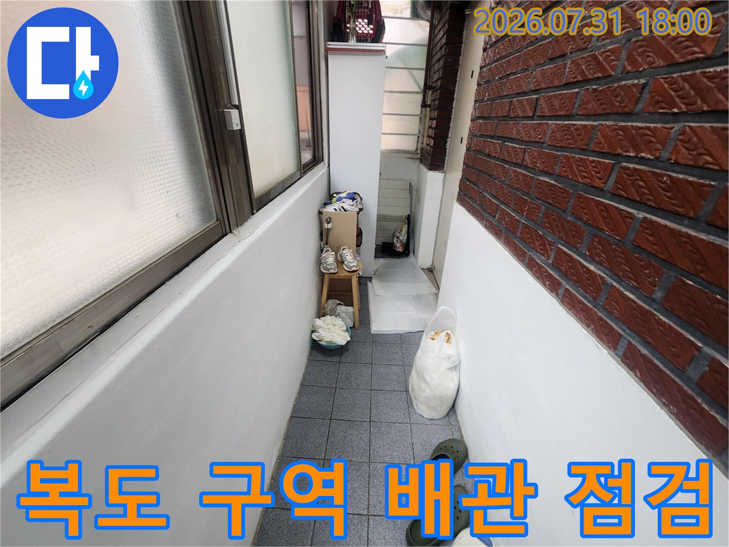 벽면 노출 배관과 작업 도구가 배치된 복도 누수 점검 현장