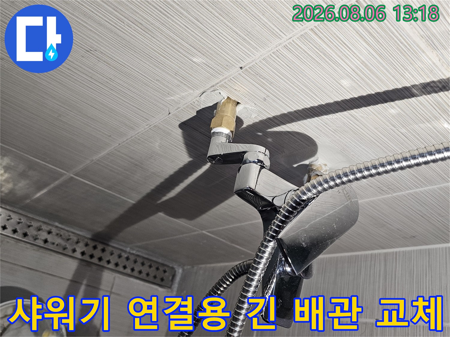 욕실 벽면의 샤워기 수전과 연결되는 길게 뻗은 배관을 보수하는 시공 장면