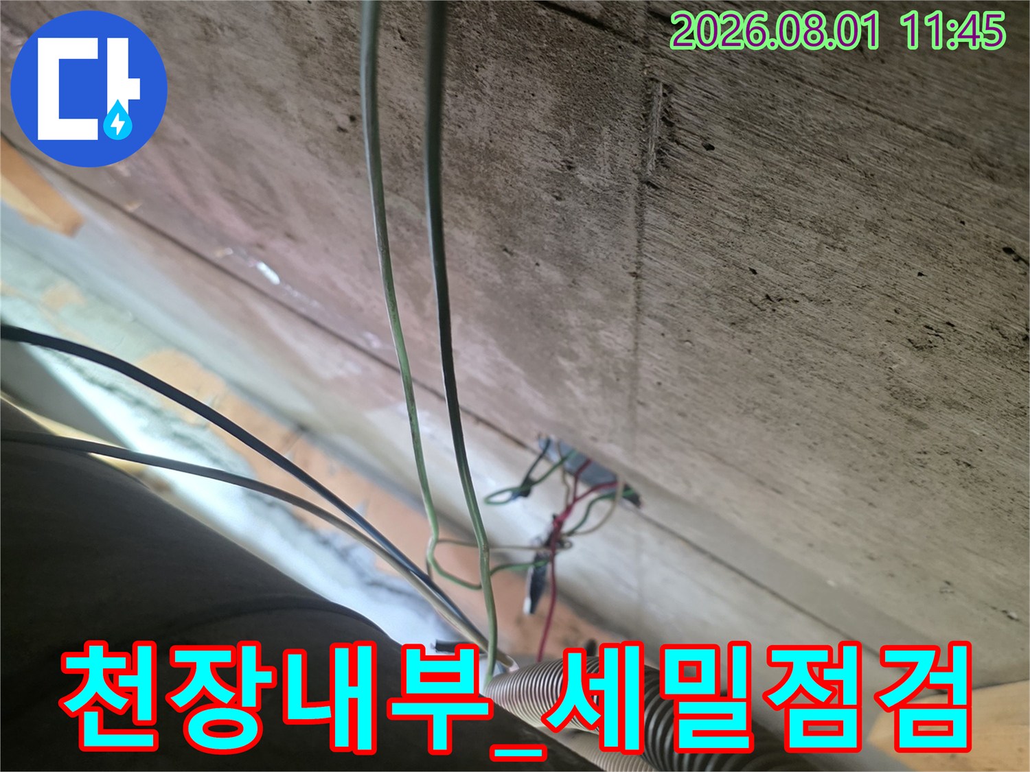 먼지가 쌓인 공간 속에서 배관과 전선 보호용 파이프를 확인하는 모습