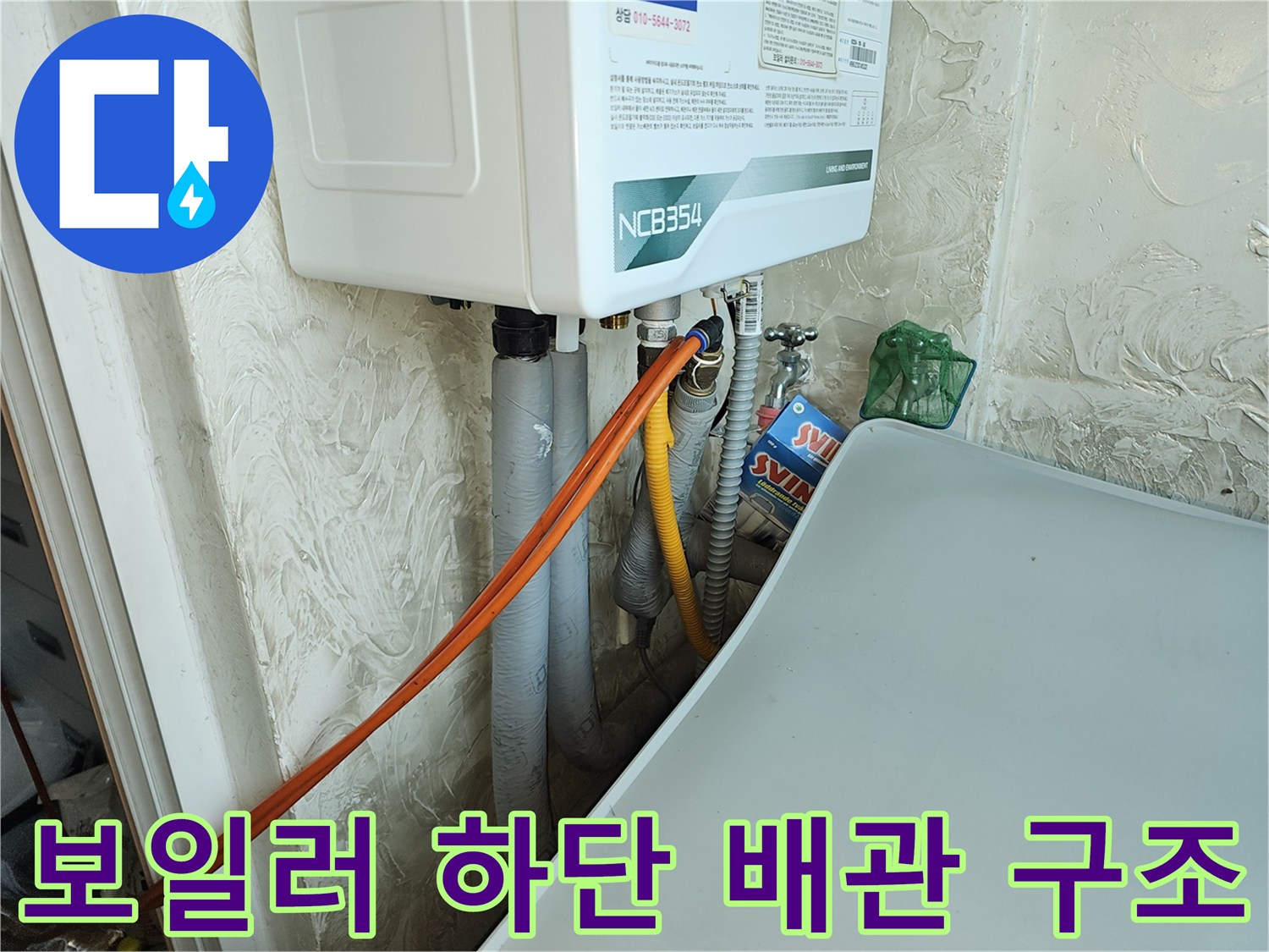 보일러 아래쪽 연결된 배관들-누수 탐지를 위해 배치된 주황색 호스